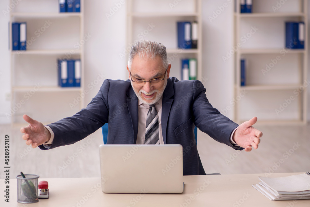 Old male employee working in the office Old male employee working in the office