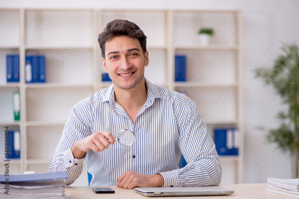 Young male employee working in the office Young male employee working in the office