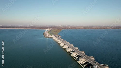 Wind Turbines And Haringvlietdam Crossing The Haringvliet In Netherlands. - aerial pullback photo