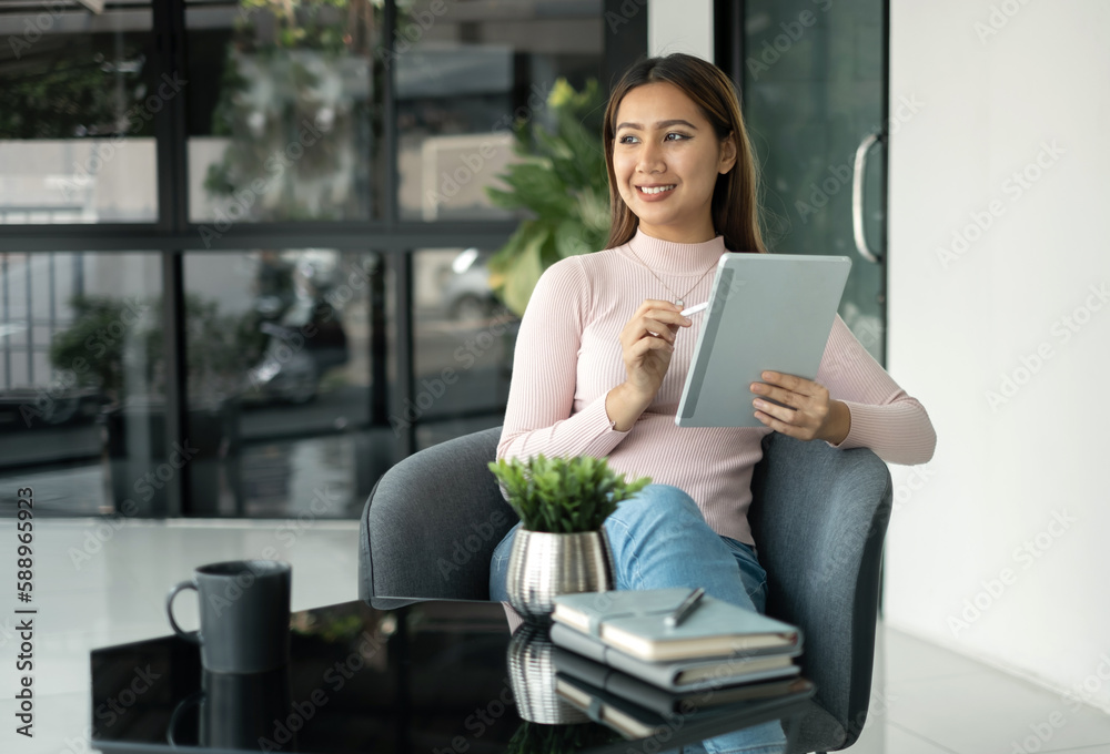 © Orathai - Female CEO in casual wear smiling and using tablet working Shown on the digital screen analyze and calculate the planning strategy for modern business