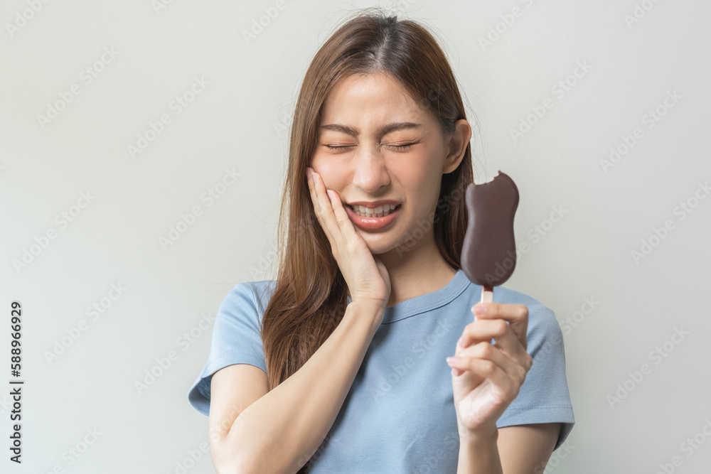 Face expression suffering from sensitive teeth and cold, asian young