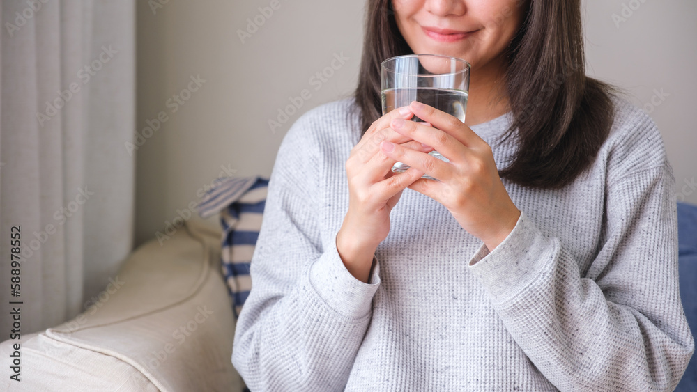Closeup image of a young woman holding and drinking water Closeup image of a young woman holding and drinking water