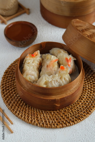 Chinese dumpling or shrimp dimsum on bamboo steamer with white background.