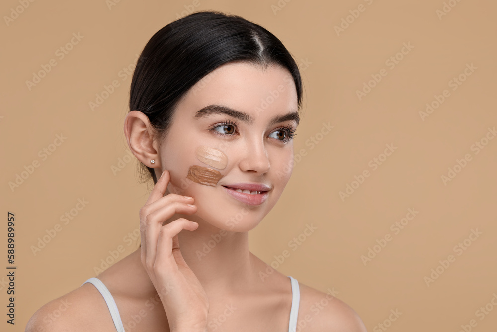 Teenage girl with swatches of foundation on face against beige background. Space for text Teenage girl with swatches of foundation on face against beige background. Space for text