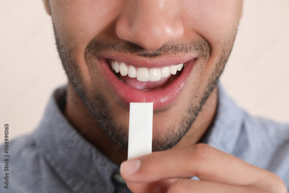Naklejka premium Man with chewing gum on blurred background, closeup