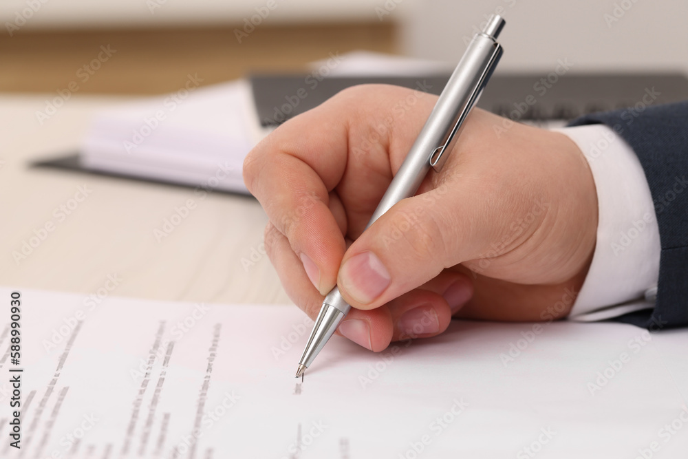 Man signing document at table, closeup view Man signing document at table, closeup view