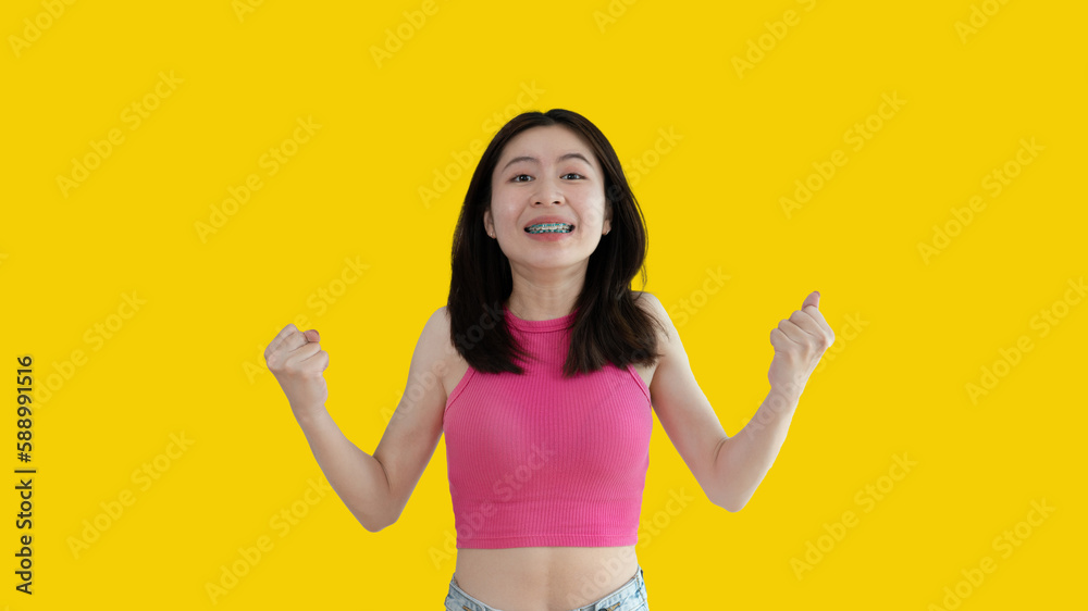 Asian woman posing extremely happy to win, Successful, Show extreme happiness, Very happy, yes, Lonely woman on yellow background. Asian woman posing extremely happy to win, Successful, Show extreme happiness, Very happy, yes, Lonely woman on yellow background.