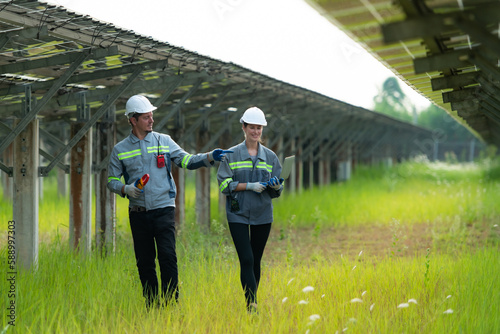 Fotografia A team of electrical engineers is inspecting and maintaining solar panels at a solar panel site in the middle of a hundred acre field