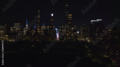 Aerial view overlooking the Central park with the Billionaires' Row in the background, night in NY USA - descending, drone shot