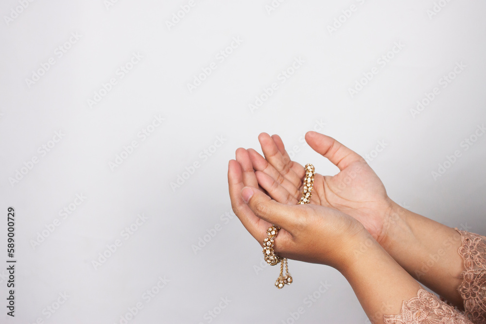 Islamic moslem woman praying with crystal tasbih wearing traditional dress