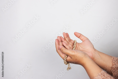 Islamic moslem woman praying with crystal tasbih wearing traditional dress