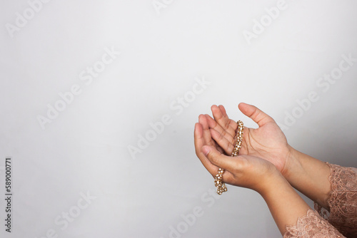 Islamic moslem woman praying with crystal tasbih wearing traditional dress