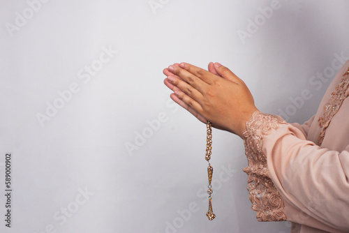 Islamic moslem woman praying with crystal tasbih wearing traditional dress