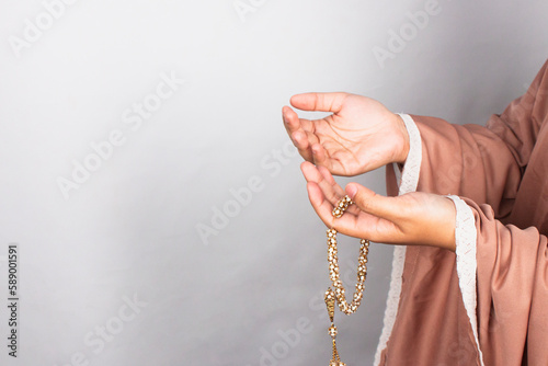 Islamic moslem woman praying with crystal tasbih wearing traditional dress