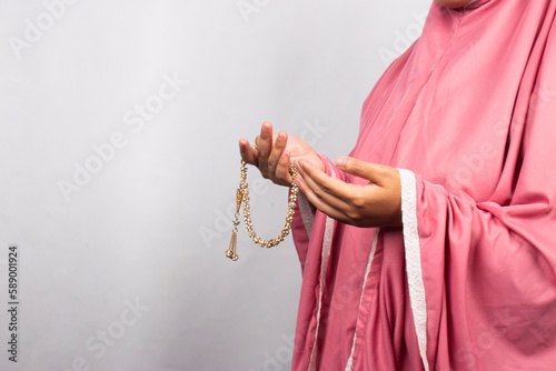 Islamic moslem woman praying with crystal tasbih wearing traditional dress