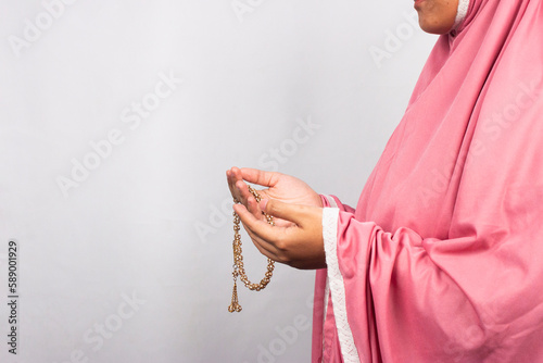 Islamic moslem woman praying with crystal tasbih wearing traditional dress