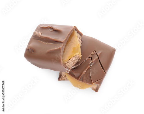 Pieces of chocolate bar with caramel on white background, top view
