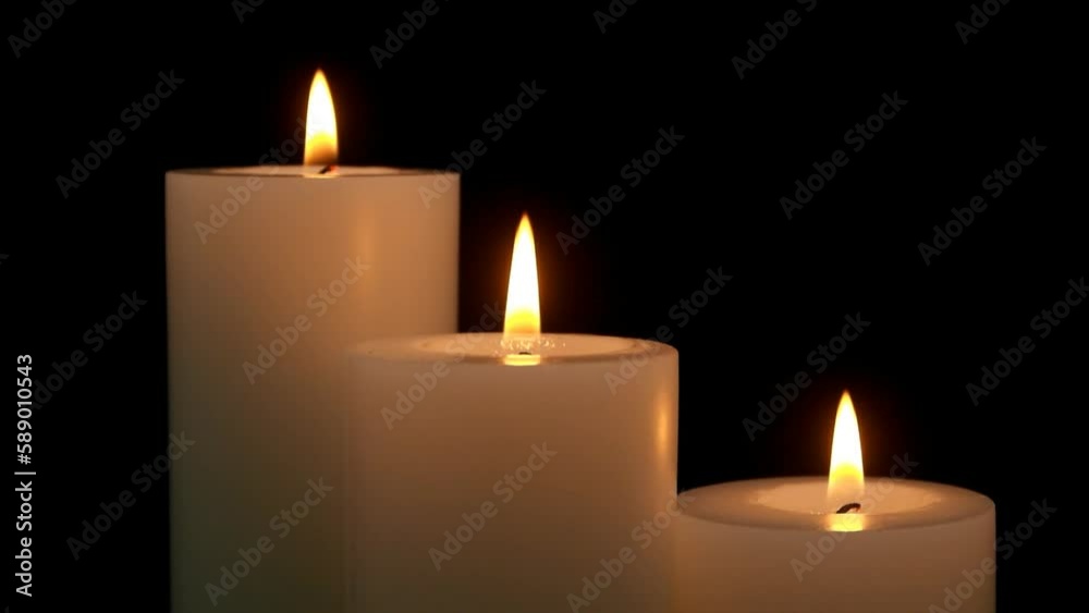 Close up of candles melting and burning in darkness Close up of candles melting and burning in darkness