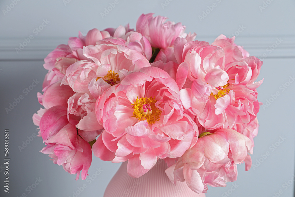 Beautiful bouquet of pink peonies in vase near grey wall, closeup Beautiful bouquet of pink peonies in vase near grey wall, closeup