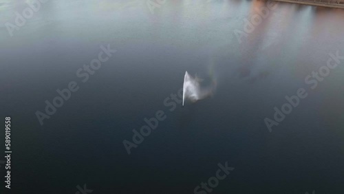 Drone shot tilting over a fountain on the Jacqueline Kennedy Onassis Reservoir, spring evening in New York city