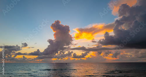 Sunset on tropical beach sea ocean with sunrise clouds. Banner for travel vacation. Scenery sky and reflection rays in water. Panorama on sea at sunset. Beautiful seascape.