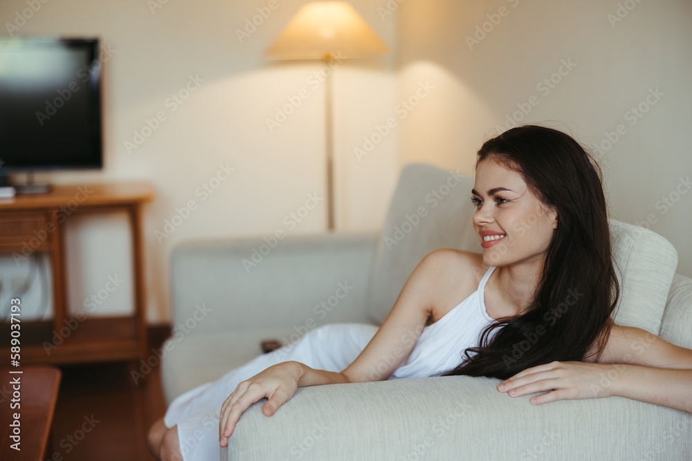 Happy girl smile lying on the couch at home, relaxing at home, comfort, sunshine. Happy girl smile lying on the couch at home, relaxing at home, comfort, sunshine.