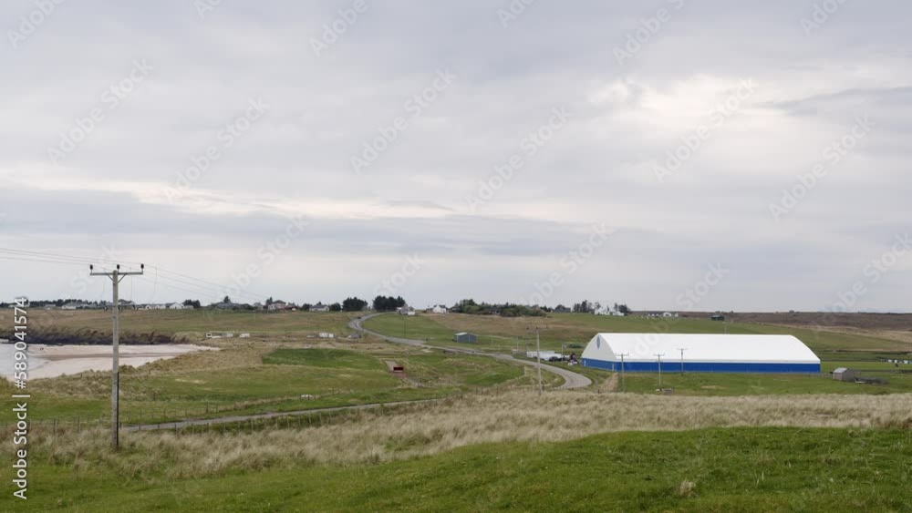 Wide shot of a football pitch, gym and recreation centre in the village of Coll on the Isle of Lewis, part of the Outer Hebrides of Scotland. A beach and a road are visible. Wide shot of a football pitch, gym and recreation centre in the village of Coll on the Isle of Lewis, part of the Outer Hebrides of Scotland. A beach and a road are visible.
