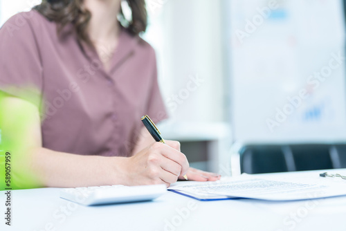 businesswoman hand writing on paper in office