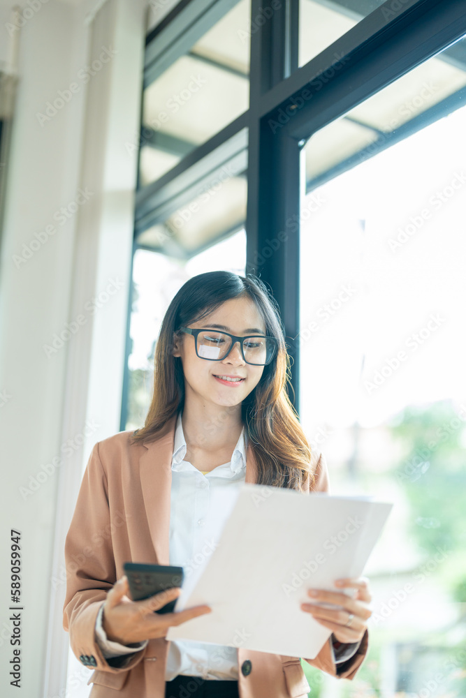 Portrait of business woman wearing suit looking at documents  and holding smartphone in hand, open air office, attic, panoramic window background, mockup, film effect landscape.