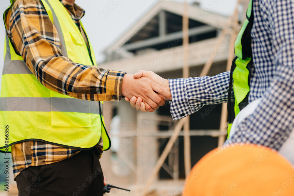 Engineer and contractor join hands after signing contract,They are having a modern building project together. successful cooperation concept Engineer and contractor join hands after signing contract,They are having a modern building project together. successful cooperation concept