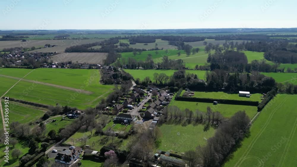 A drone captures the Kent village of Nonington from a high altitude, providing a unique perspective of the village on a sunny day with blue skies and green fields. A drone captures the Kent village of Nonington from a high altitude, providing a unique perspective of the village on a sunny day with blue skies and green fields.