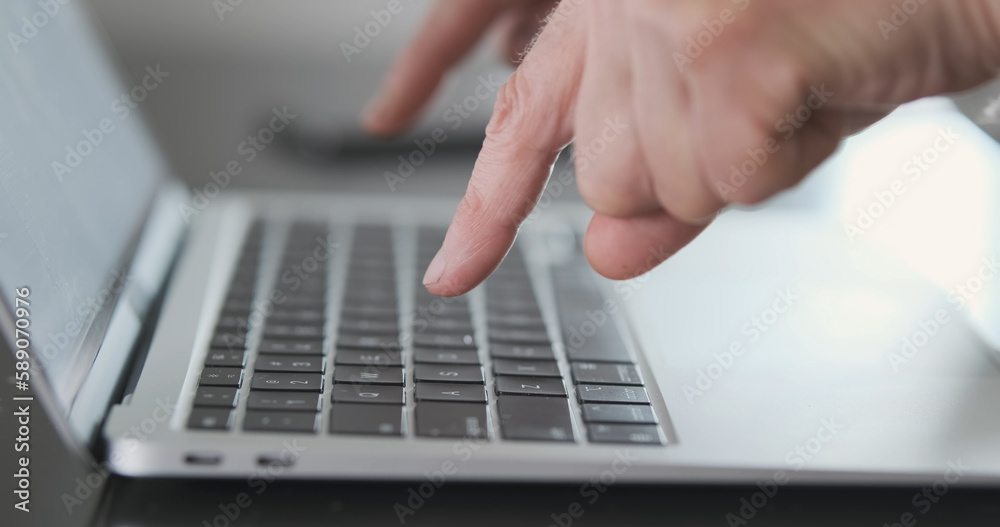Grandma is very slow at typing on computer keyboard with only her index fingers. Close-up, side view, unrecognizable. Grandma is very slow at typing on computer keyboard with only her index fingers. Close-up, side view, unrecognizable.