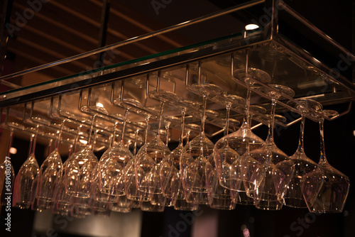 Hanging glasses over the bar, many clean glasses