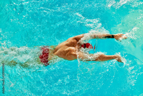 Aerial Top View Male Swimmer Swimming in Swimming Pool. Professional Athlete Training for the Championship, using Front Crawl, Freestyle Technique. Top View Shot