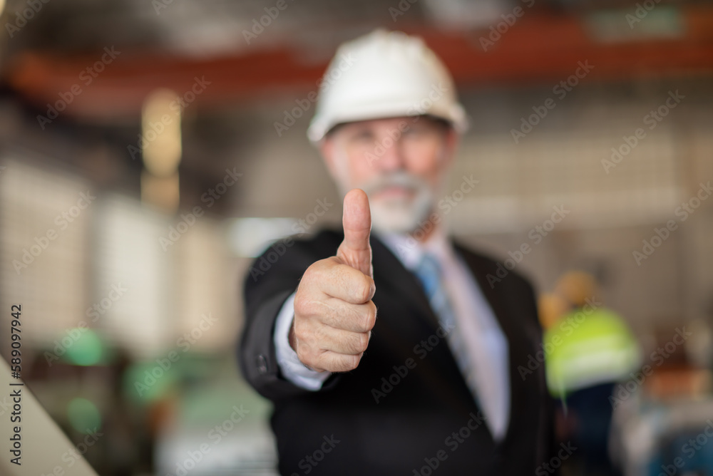 older owner engineer with beard mustache on face standing smile with his arms crossed at construction factory site. Boss manager in suit show good thumb at factory industry site. older owner engineer with beard mustache on face standing smile with his arms crossed at construction factory site. Boss manager in suit show good thumb at factory industry site.