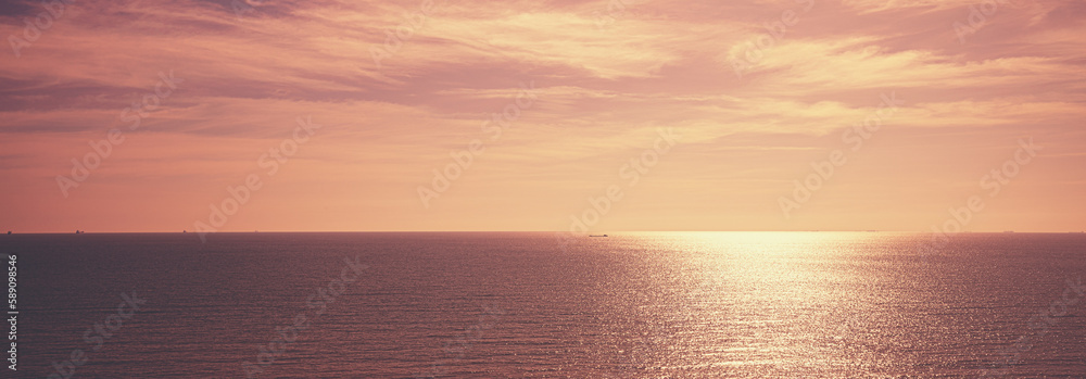 Seascape in the early morning. Beautiful cold sunrise with a clear sky over the calm sea. Sunny path on the sea. Horizontal banner