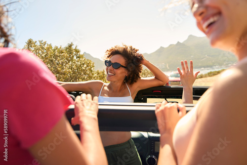 Canvastavla Female Friends Standing Up Through Sun Roof Car And Dancing On Road Trip Through