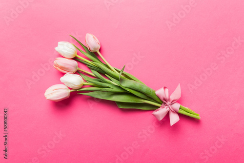 Bouquet of pink tulips on colored table background . Top view with copy space. Waiting for spring. Happy Easter card. Flat lay