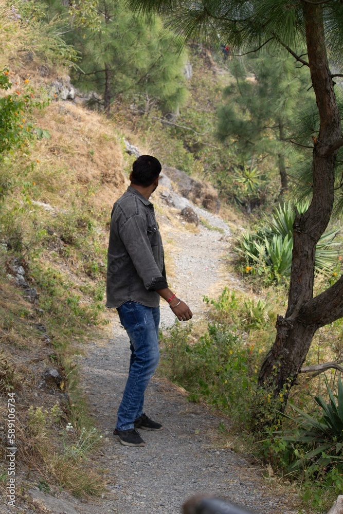Vertical shot of a south Asian man standing in a park against blurred background Vertical shot of a south Asian man standing in a park against blurred background