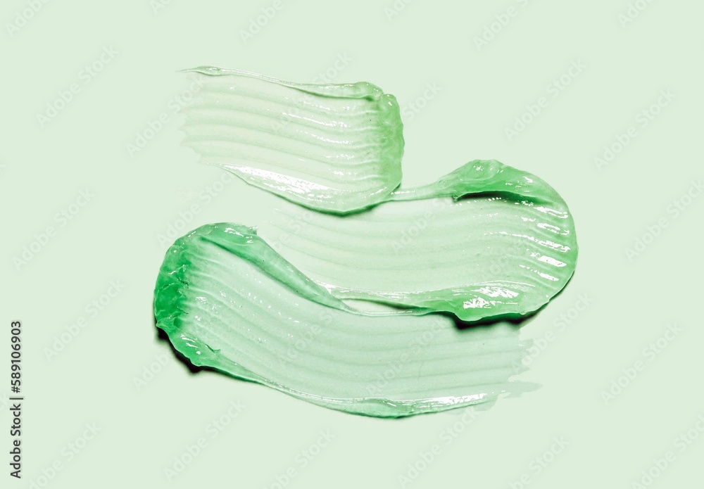 Fototapeta premium Liquid gel cosmetic smudge green vaseline green isolated on pastel