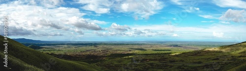 Panoramic shot of green landscapes under a cloudy sky