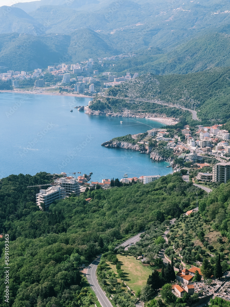 Modern high-rise buildings on the coast of the Bay of Kotor among green trees