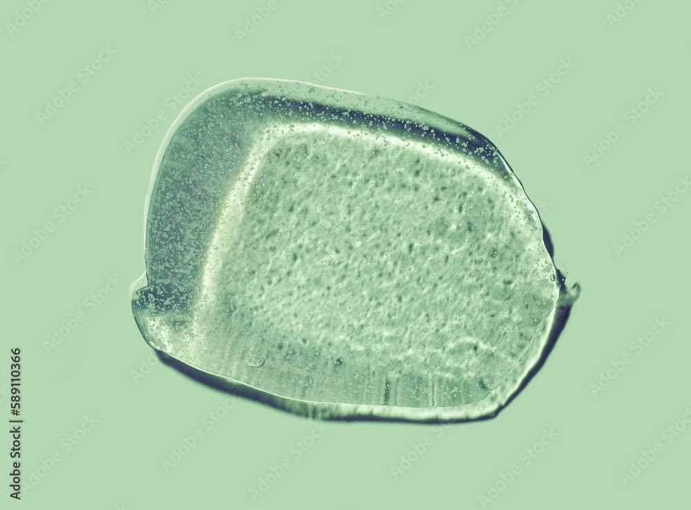 Liquid gel cosmetic smudge green shimmering gloss isolated on pastel sage khaki green Liquid gel cosmetic smudge green shimmering gloss isolated on pastel sage khaki green