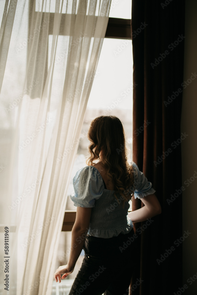 Romantic morning. The girl opens the window