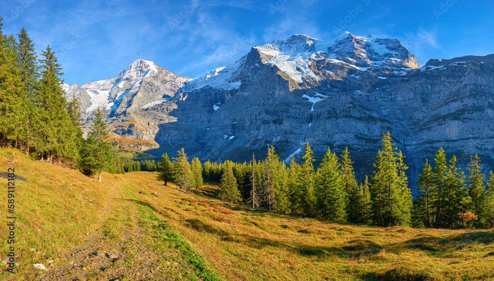 Naklejka premium Mountains panorama view of Monch and Jungfrau peaks from hiking trail near Wengen alpine village in Switzerland.