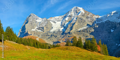 Canvas Print Impressive mountains panoramic view of Eiger and Monch peaks from hiking trail near Wengen alpine village in Switzerland