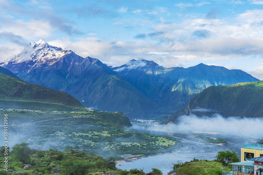 The beautiful scenery of the snowy mountains and villages in the Nyingchi Mountains of Tibet, China on June 11, 2022 The beautiful scenery of the snowy mountains and villages in the Nyingchi Mountains of Tibet, China on June 11, 2022