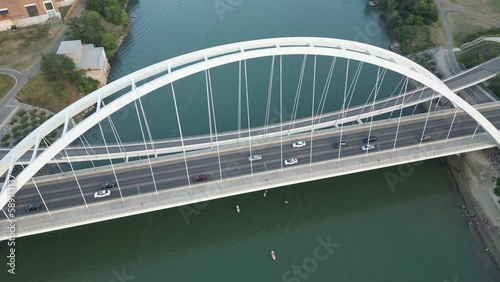 Bird's eye view of the cars driving on the Puente de la Barqueta bridge over the river photo