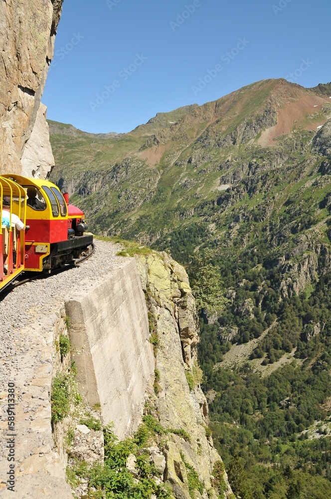 Obraz premium Train passing a vast mountainous landscape in the countryside