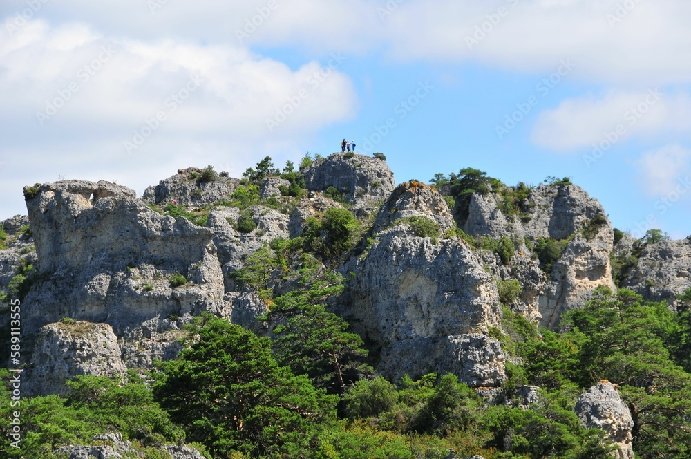 View of the cliffs surrounded by green vegetation against the background of the sky.